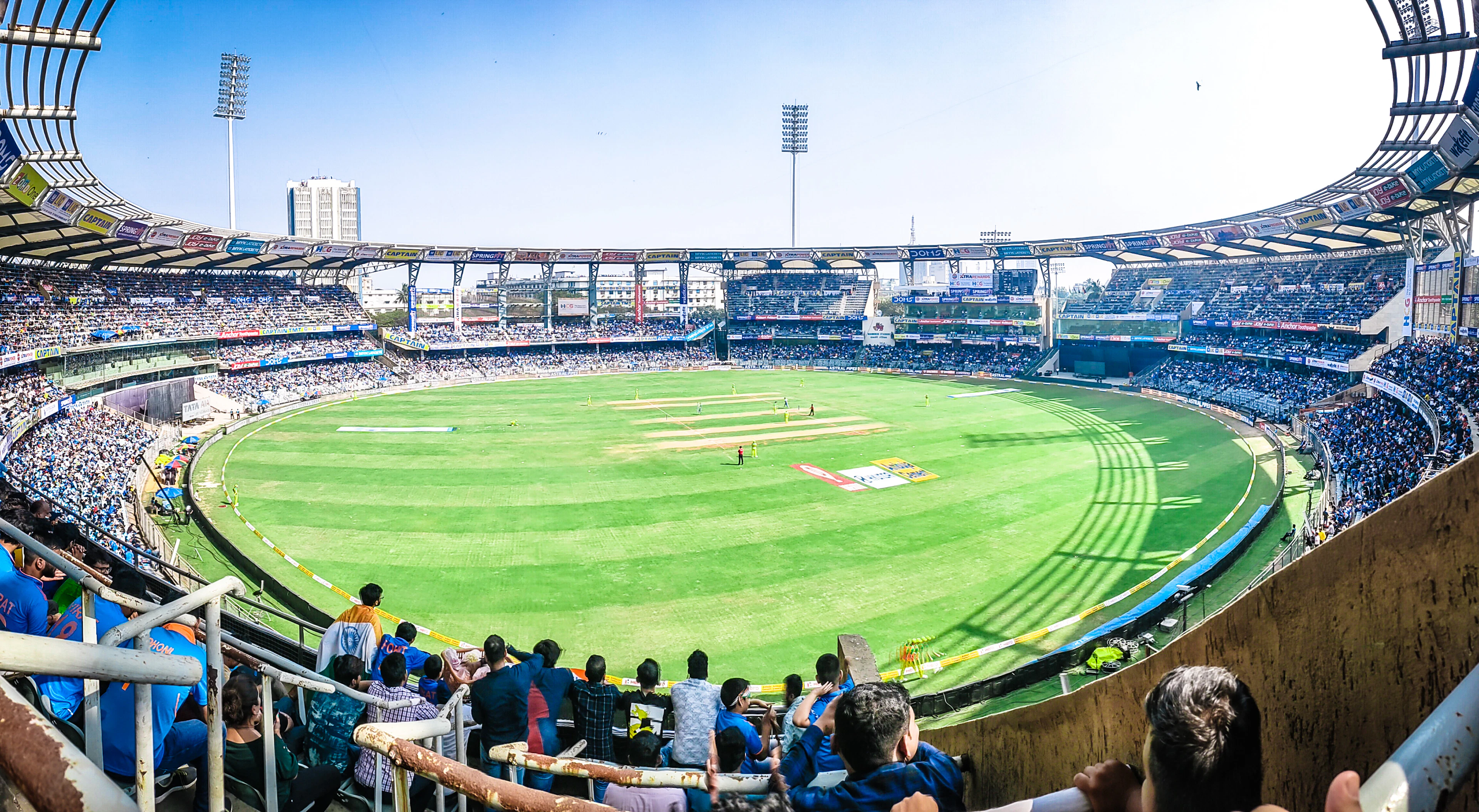 Cricket stadium with spectators and a green field