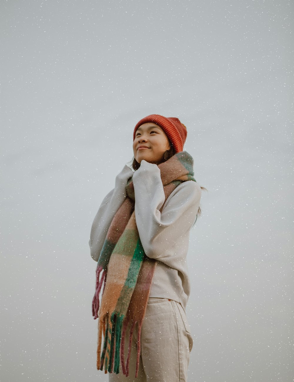 woman in gray coat and red knit cap