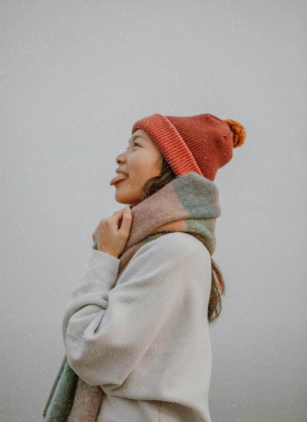 woman in white sweater and red knit cap