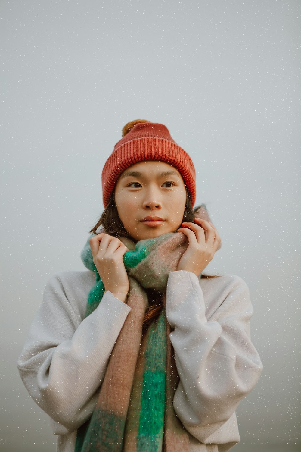 woman in white coat and red knit cap