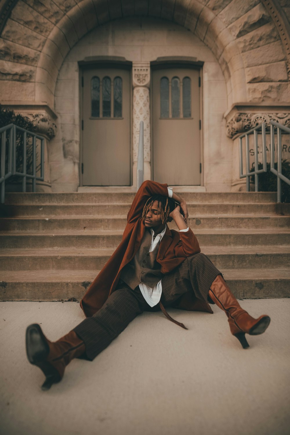 man in black leather jacket sitting on stairs