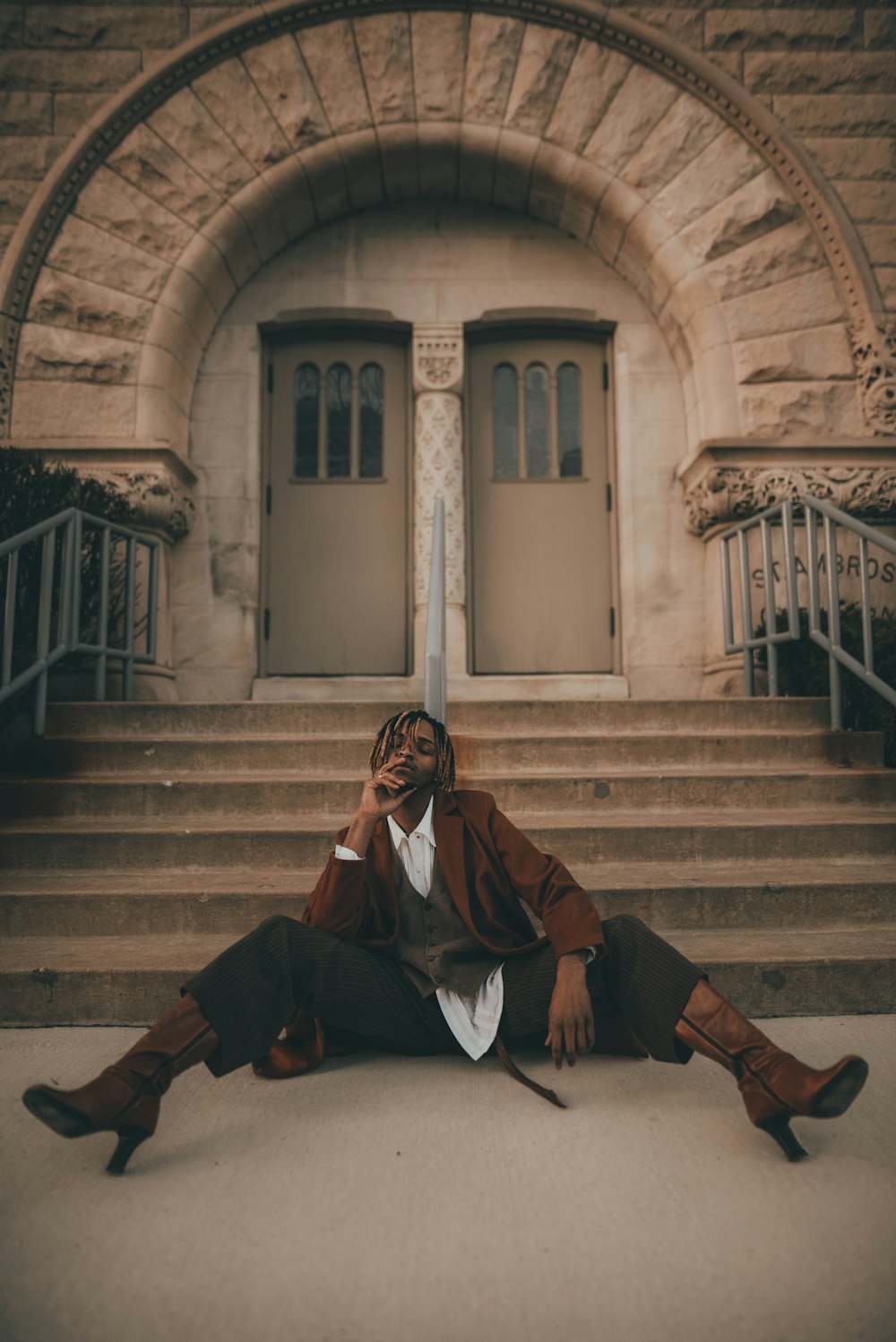 man in brown coat sitting on stairs