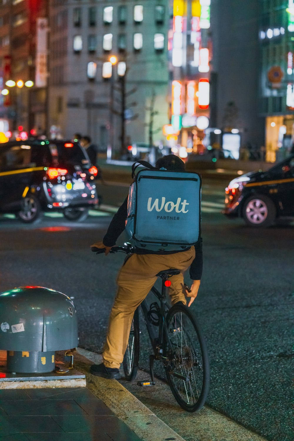 黒いジャケットとブルーデニムジーンズの男が昼間、黒いバイクに乗って道路を走る