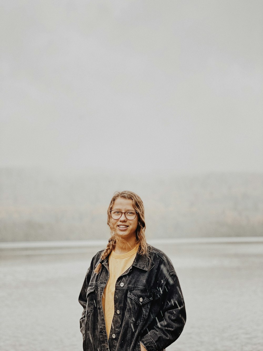 woman in black leather jacket standing on snow covered ground during daytime