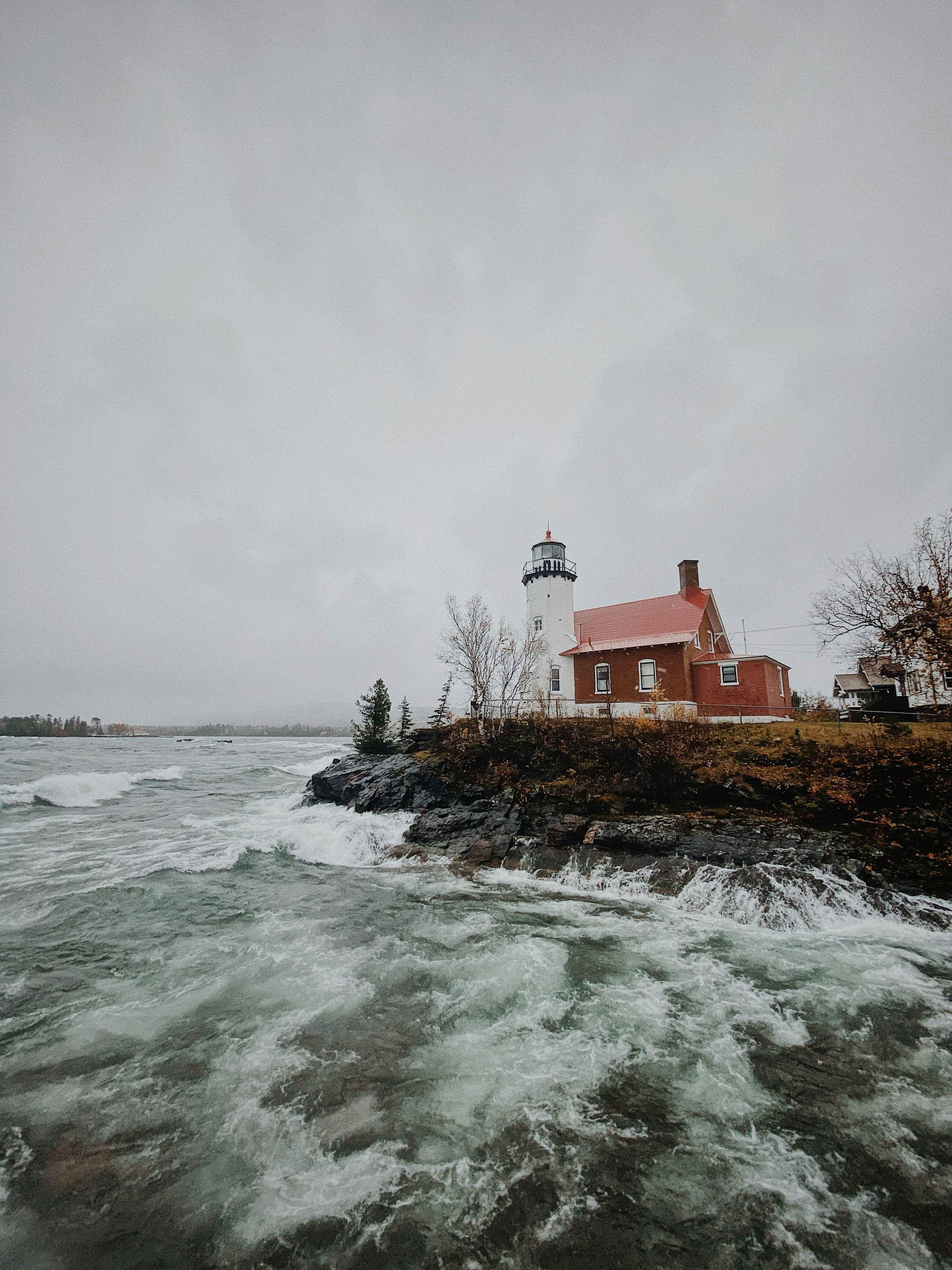 casa in cemento rosso e bianco vicino allo specchio d'acqua durante il giorno