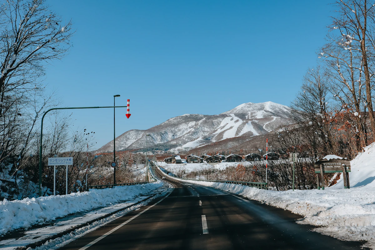 Snow covered Japanese mountain village with steaming hot spring town below