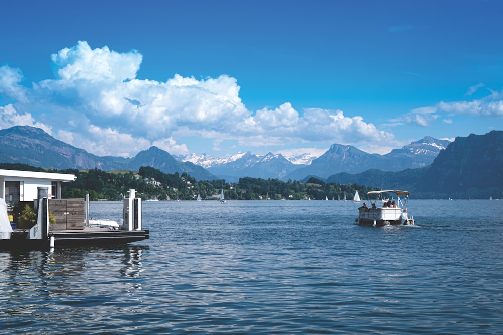 white boat on sea near mountain under blue sky during daytime