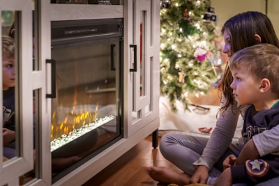woman in gray long sleeve shirt sitting on floor beside fireplace