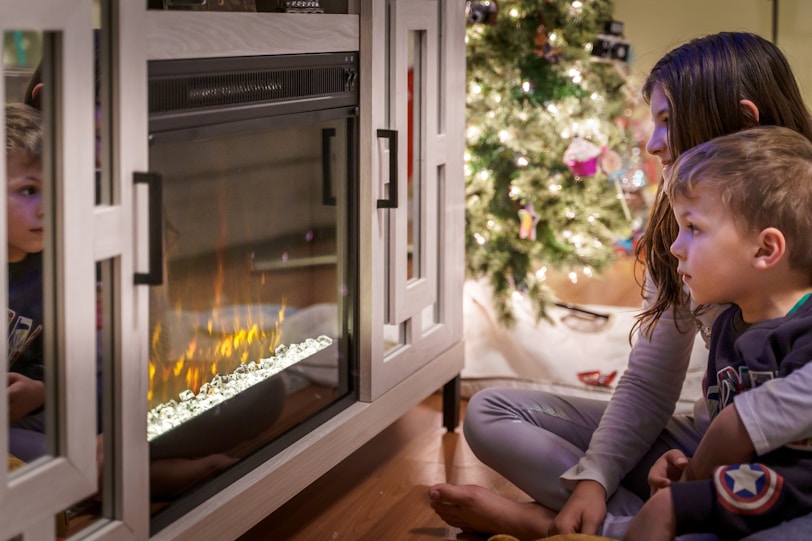 woman in gray long sleeve shirt sitting on floor beside fireplace