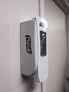 Touch dispensers mounted on a sterile white wall in a clinic.