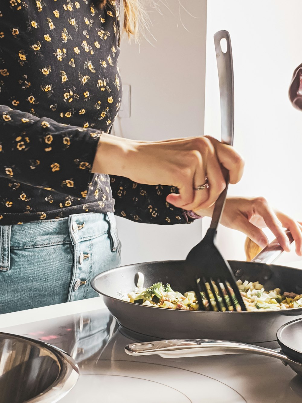 person in blue denim jacket holding black plastic ladle