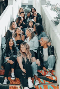 A diverse group of friends wearing casual streetwear, laughing on city steps.