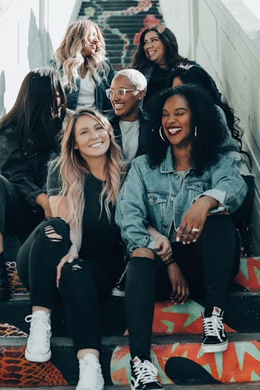 Group of friends smiling and sitting together, representing social support and community.