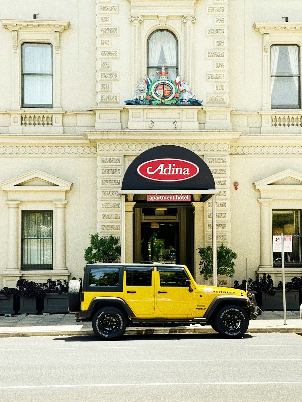 yellow and black mini cooper parked beside white concrete building during daytime