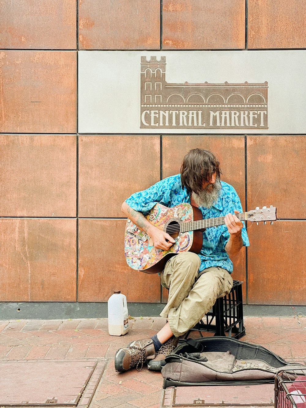 man in blue and white floral shirt playing white acoustic guitar