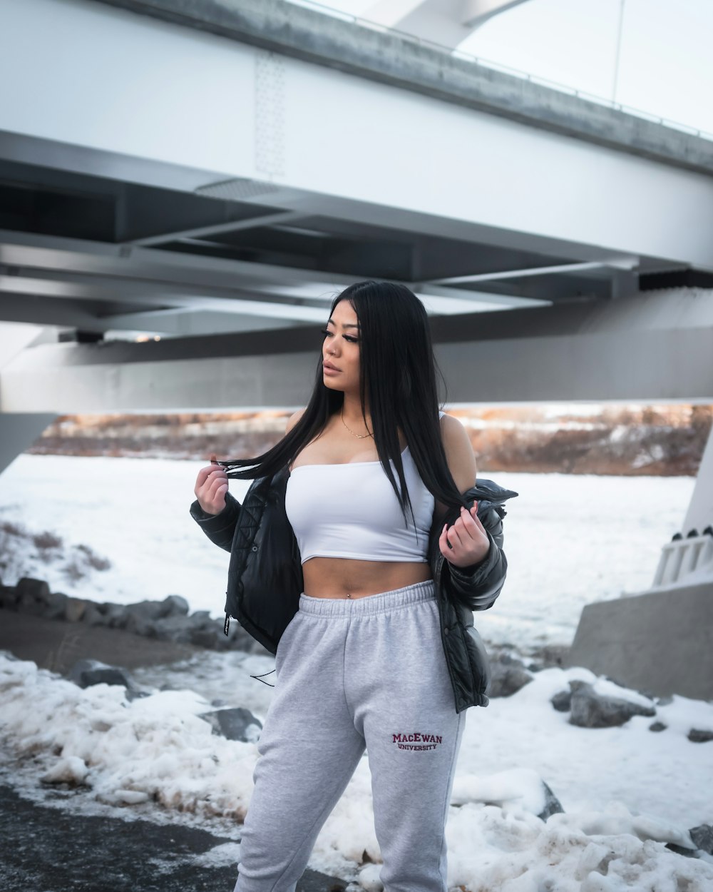 woman in black tank top and gray pants standing on snow covered ground during daytime