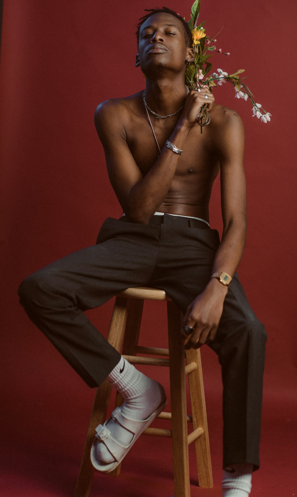 man in black pants sitting on brown wooden chair