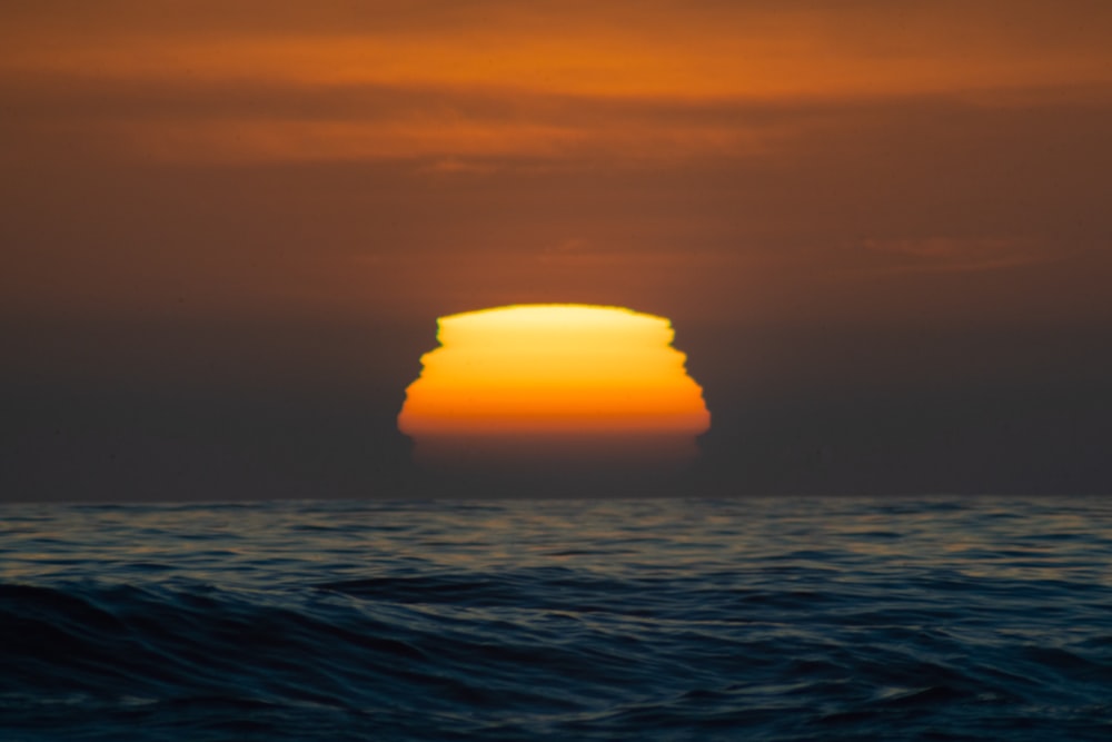 ocean waves under gray sky during sunset