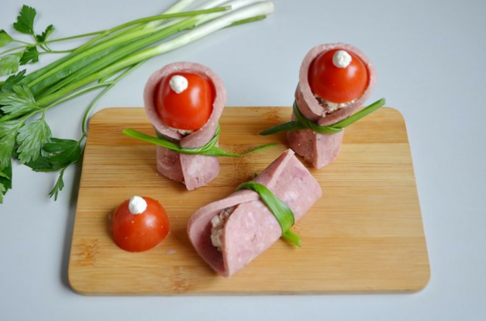 sliced tomato and green vegetable on brown wooden chopping board