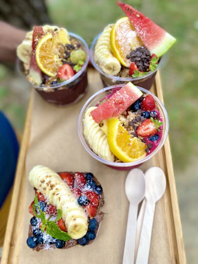 A vibrant tropical fruit bowl with açaí and colorful Brazilian fruits on a wooden table.