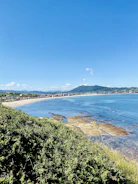 The scenic Banten coastline with seaweed farms stretching into the clear blue waters under a bright sky.