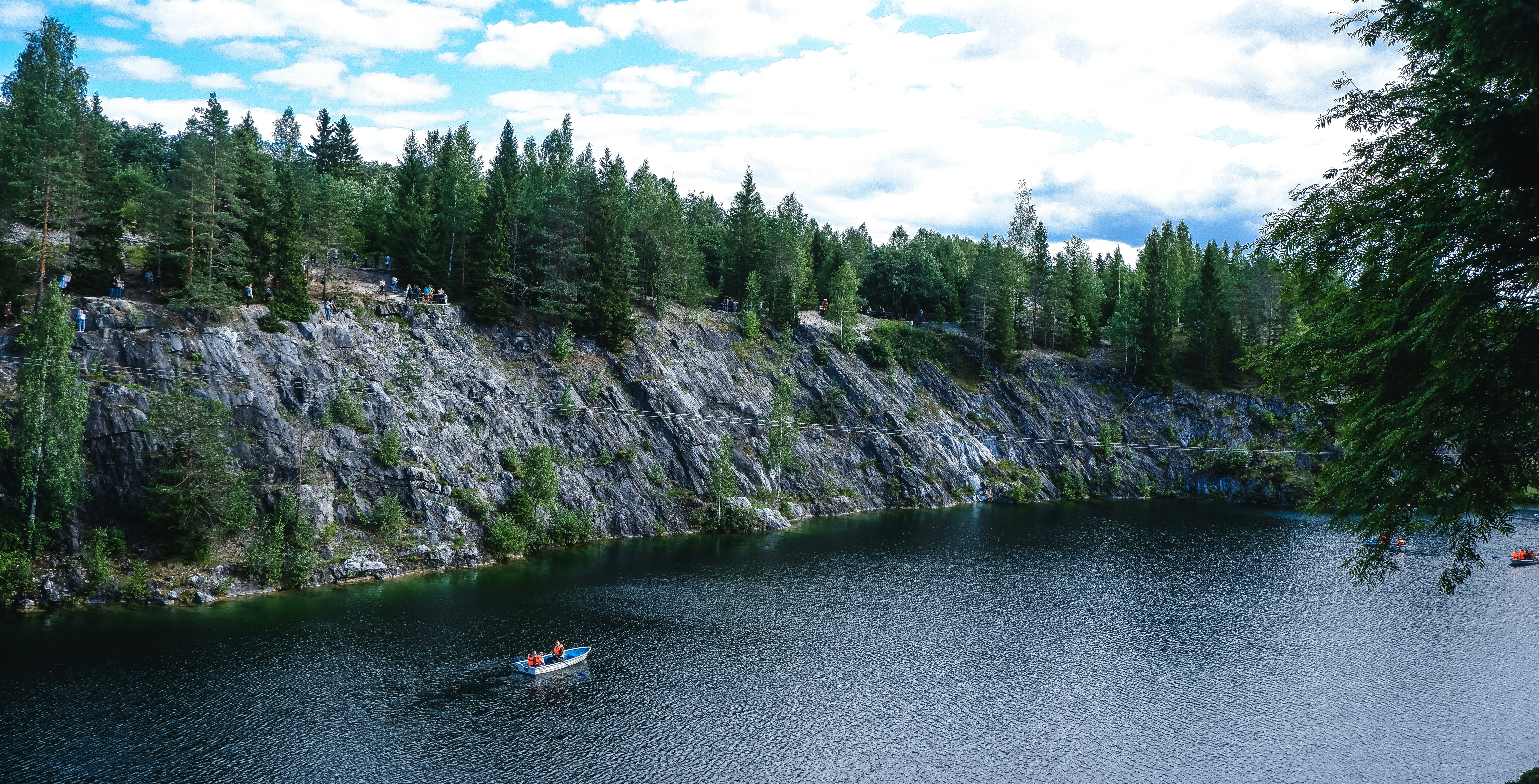 people riding on white boat on river near green trees during daytime