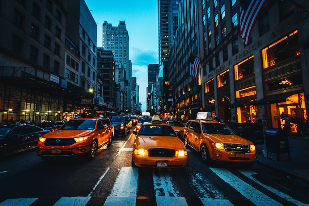 yellow car on road in between high rise buildings during daytime