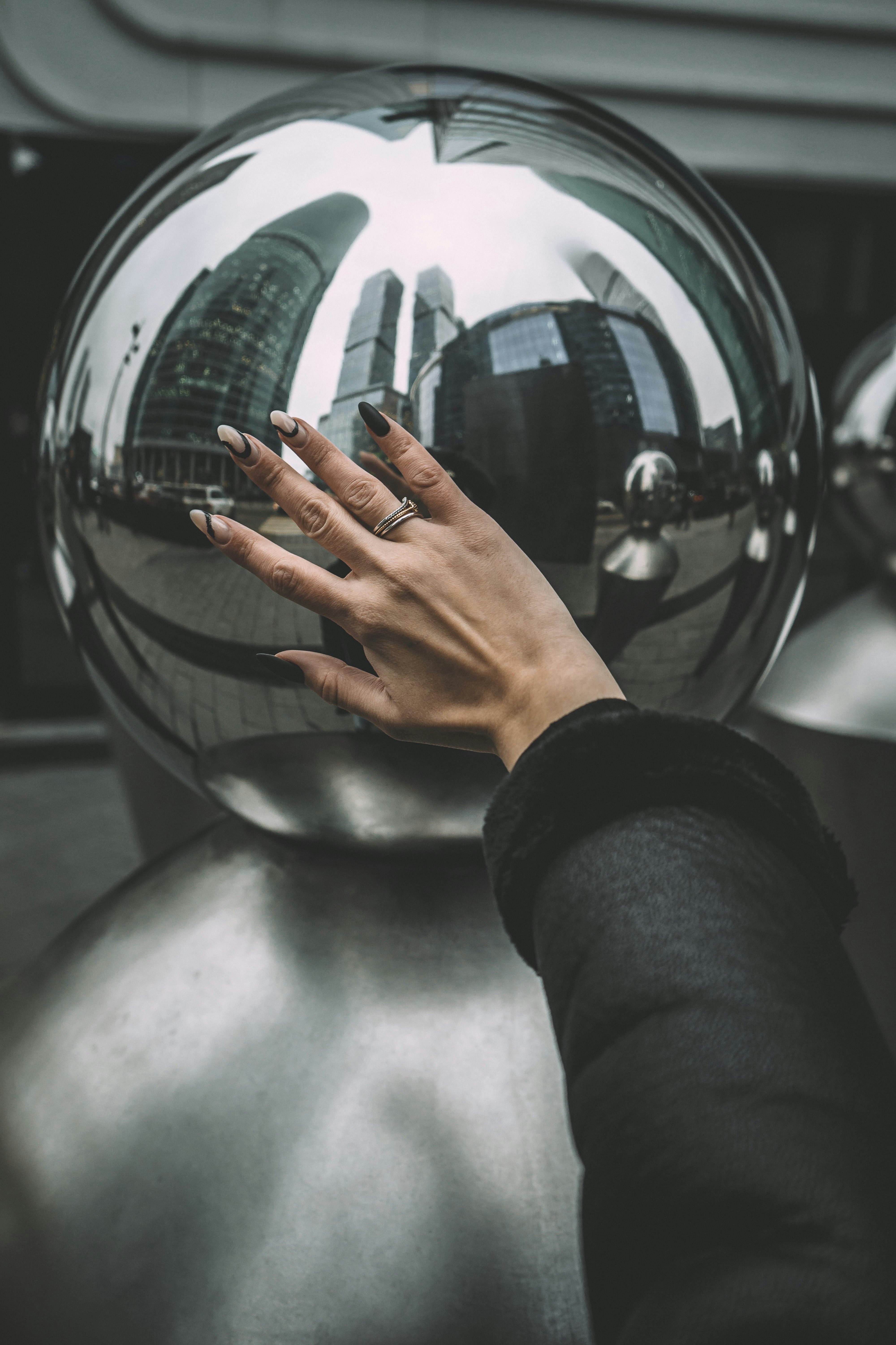 person in black long sleeve shirt holding silver ball