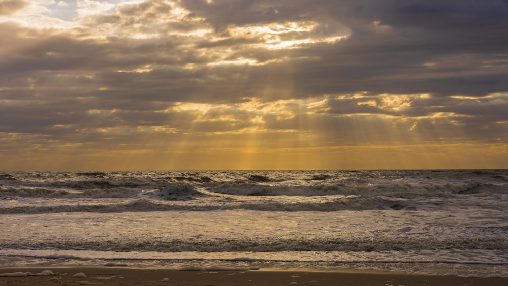 ocean waves crashing on shore during sunset