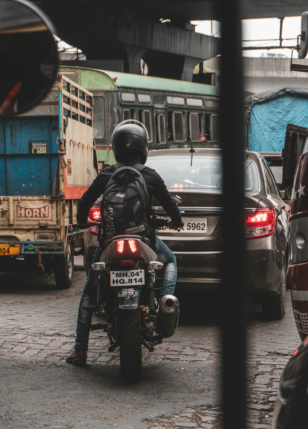 man in black jacket and helmet riding motorcycle on road during daytime