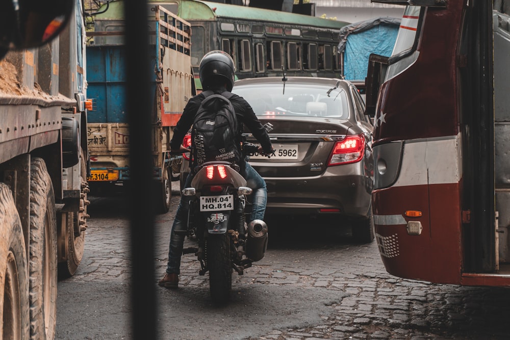 man in black helmet riding black motorcycle on road during daytime