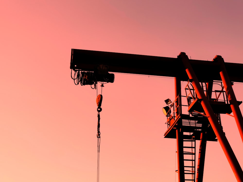 black and orange crane under orange sky