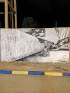 Behind-the-scenes photo of a disabled artist painting a mural.