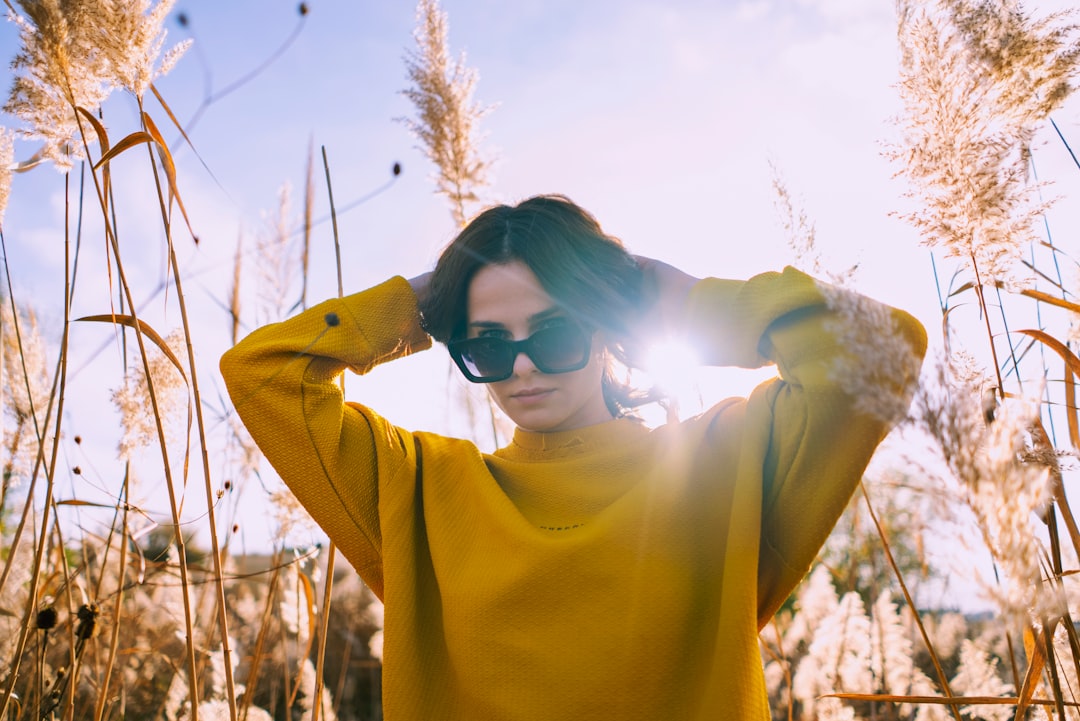 woman in yellow sweater wearing black sunglasses