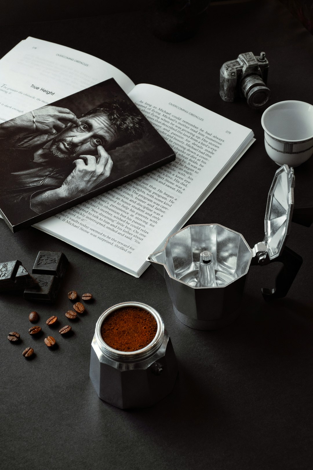 white ceramic mug beside white printer paper on black table