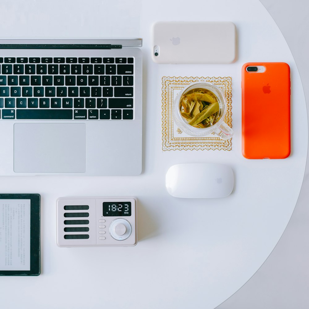 white and black laptop computer beside white ceramic mug