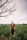 man in brown sweater standing on green grass field during daytime