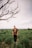 man in brown sweater standing on green grass field during daytime