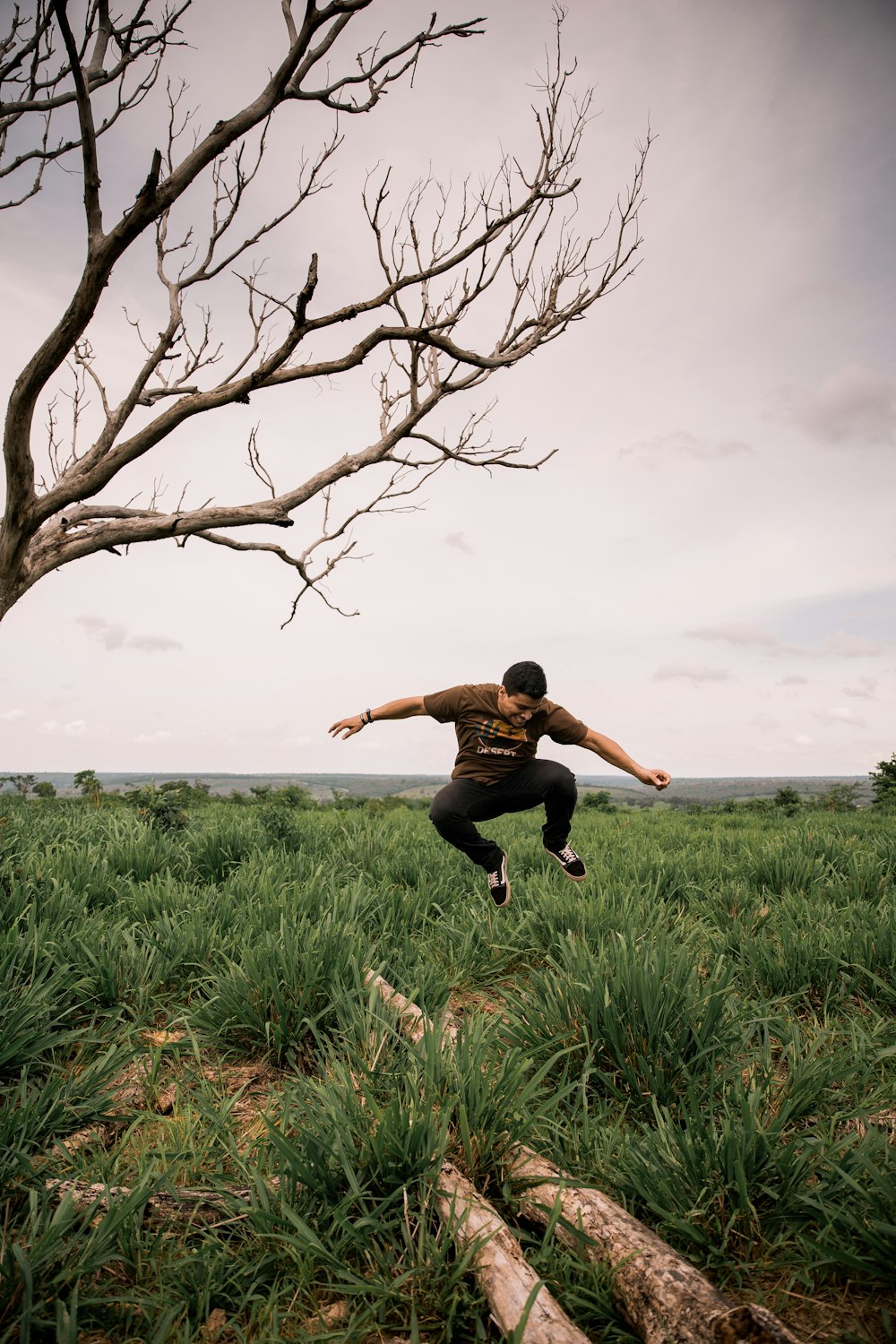 man in black shirt jumping on green grass field during daytime