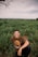 man in brown crew neck t-shirt sitting on green grass field during daytime