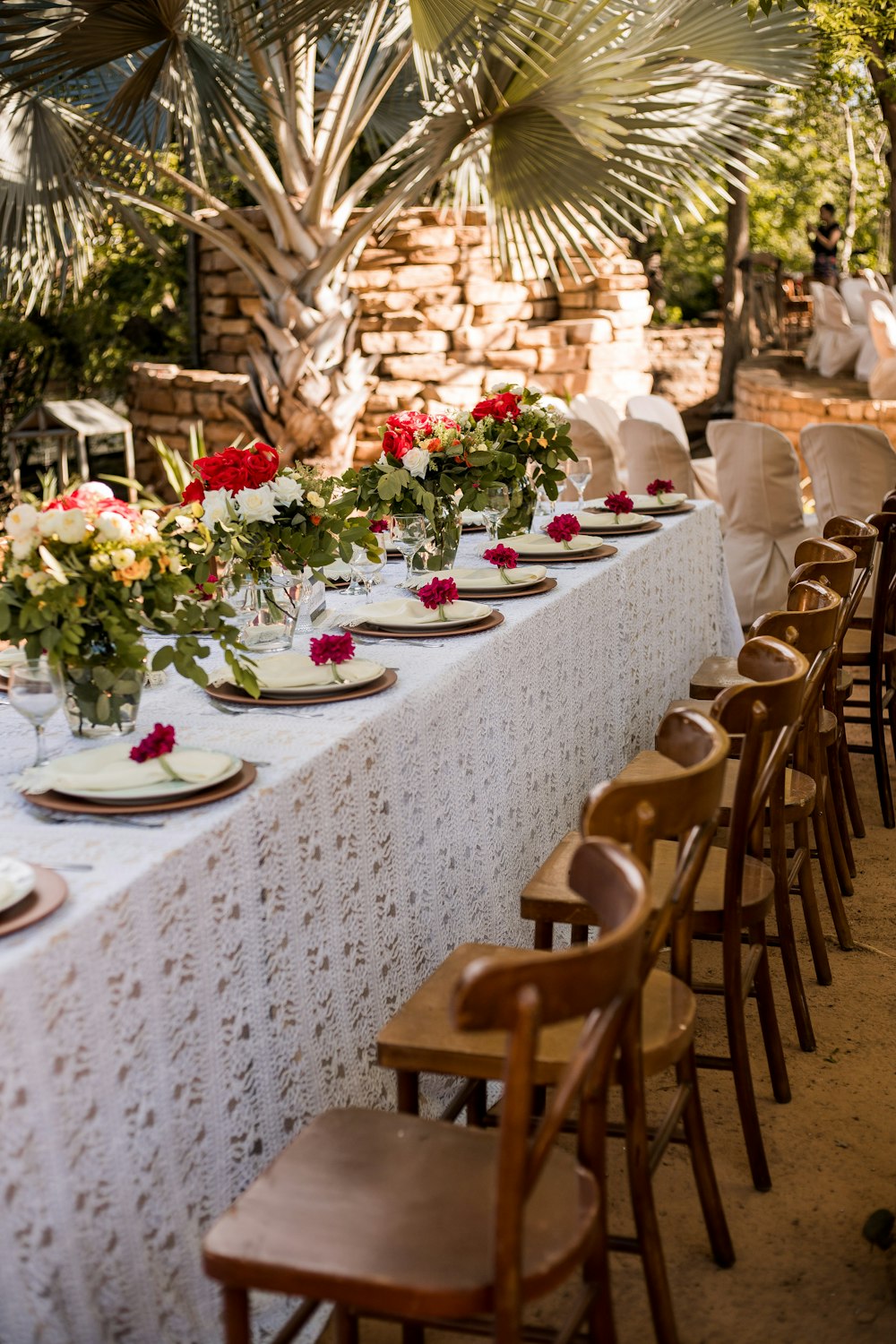 cadeiras de madeira marrom e mesa com flores no topo