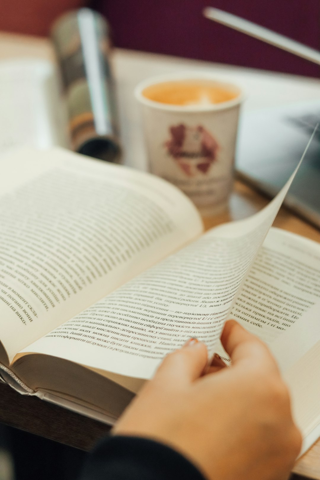 person reading book on table