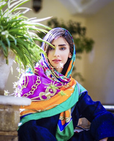 A vibrant, patterned scarf draped over a vintage chair in a cozy room.