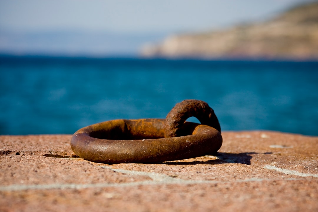 brown steel ring on brown sand near body of water during daytime