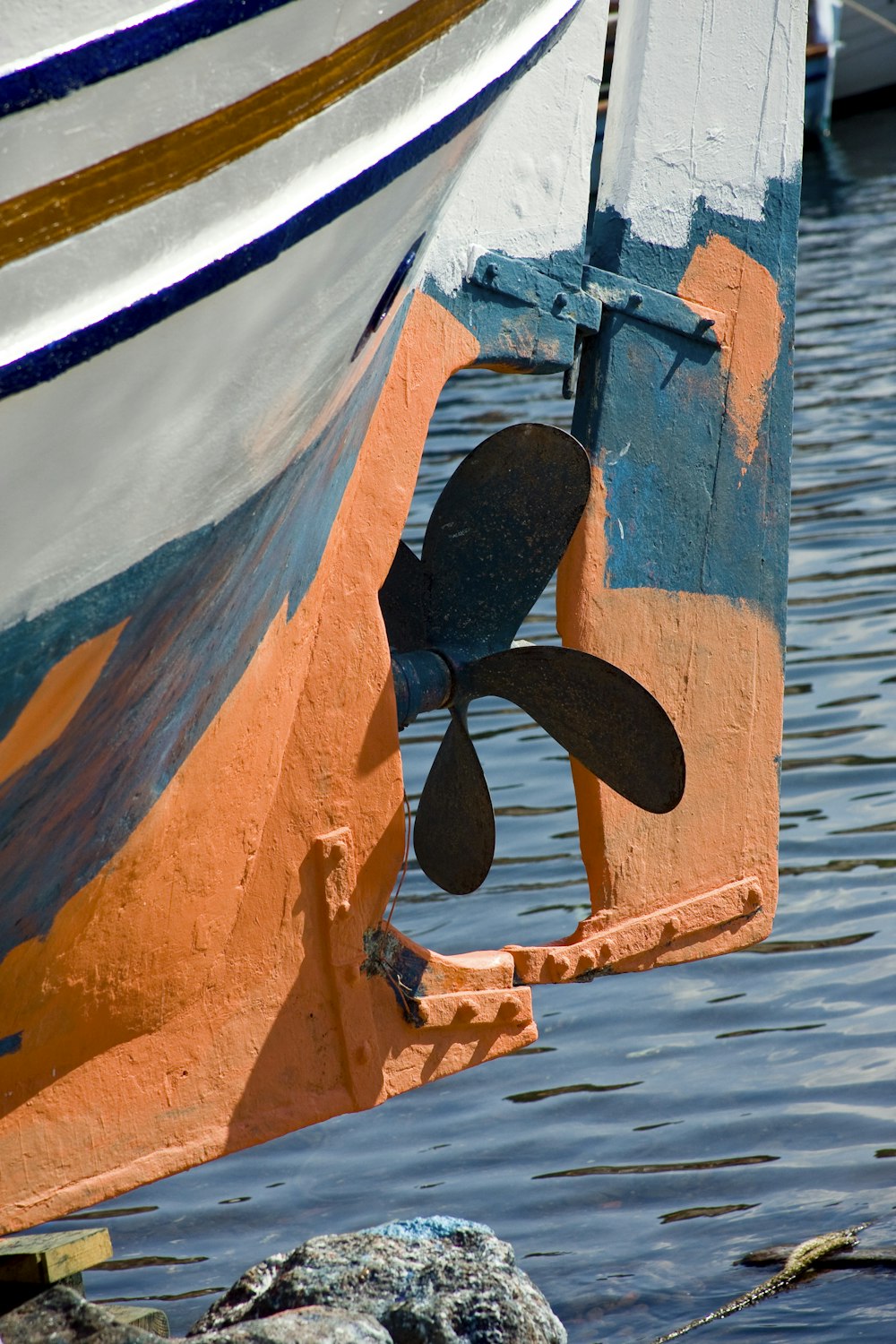 black and white surfboard on blue and white boat during daytime