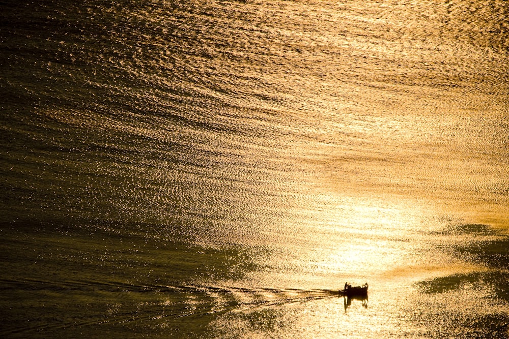 personne en chemise noire et pantalon noir debout sur le bord de la mer pendant la journée