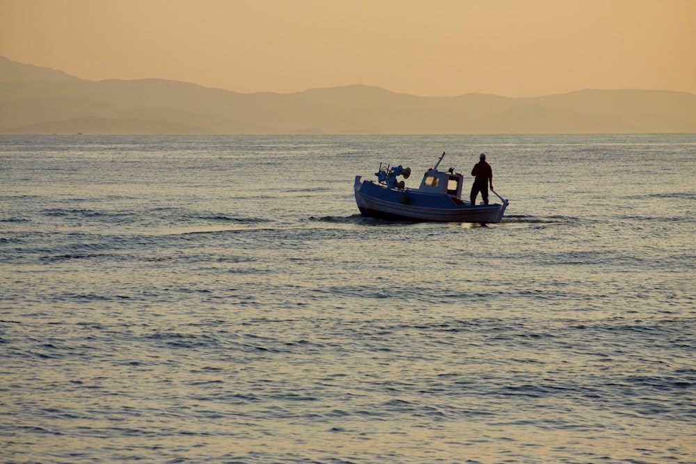 2 people riding on boat on sea during sunset