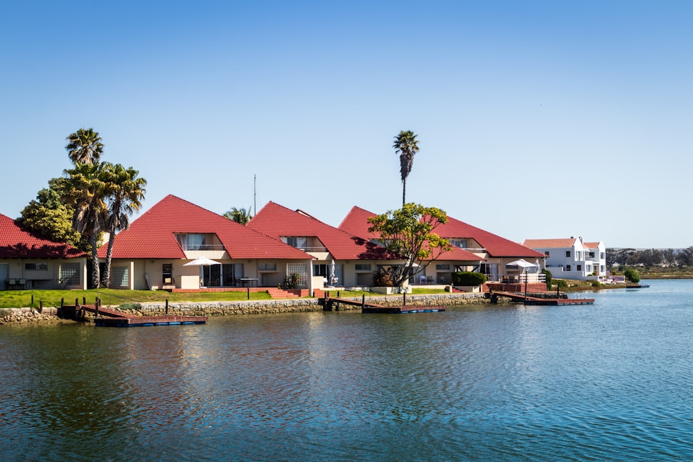 red and white house beside body of water during daytime