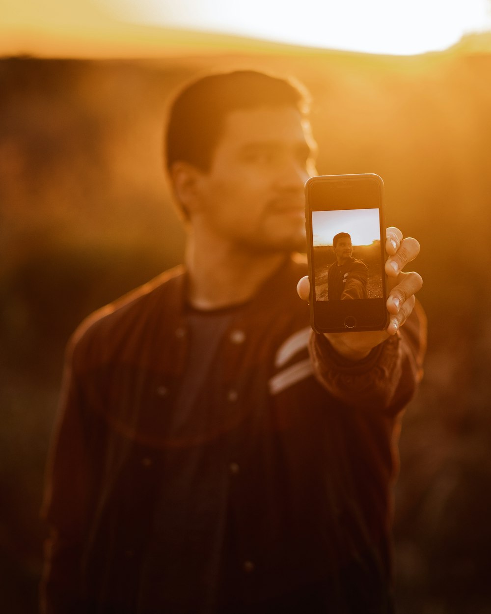 man in black button up shirt holding iphone