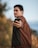 man in brown long sleeve shirt holding black smartphone